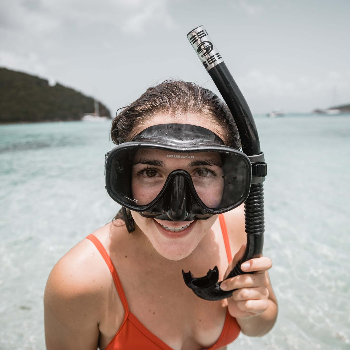 Woman with snorkel in front of the ocean