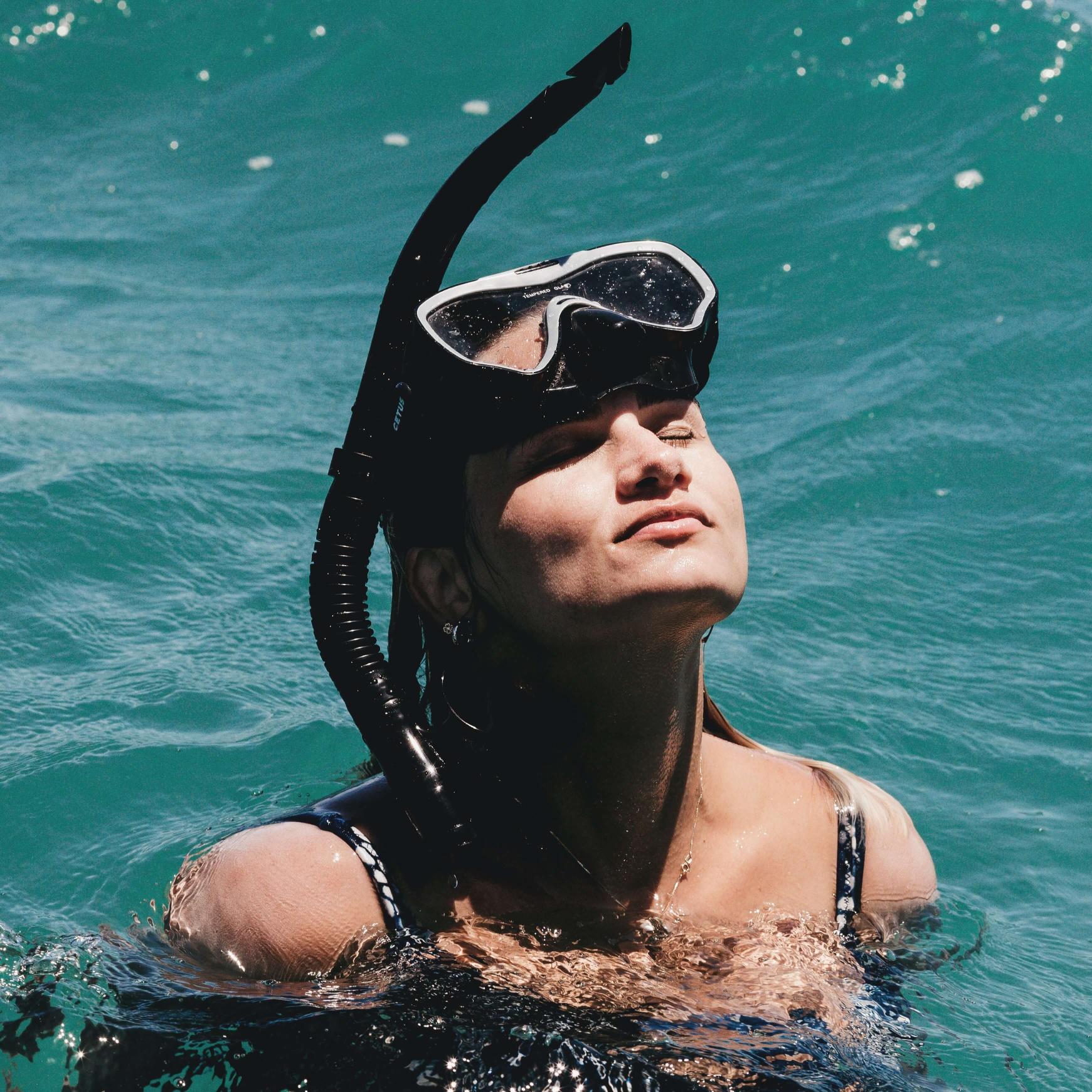 Woman with snorkel & divemask standing in the ocean